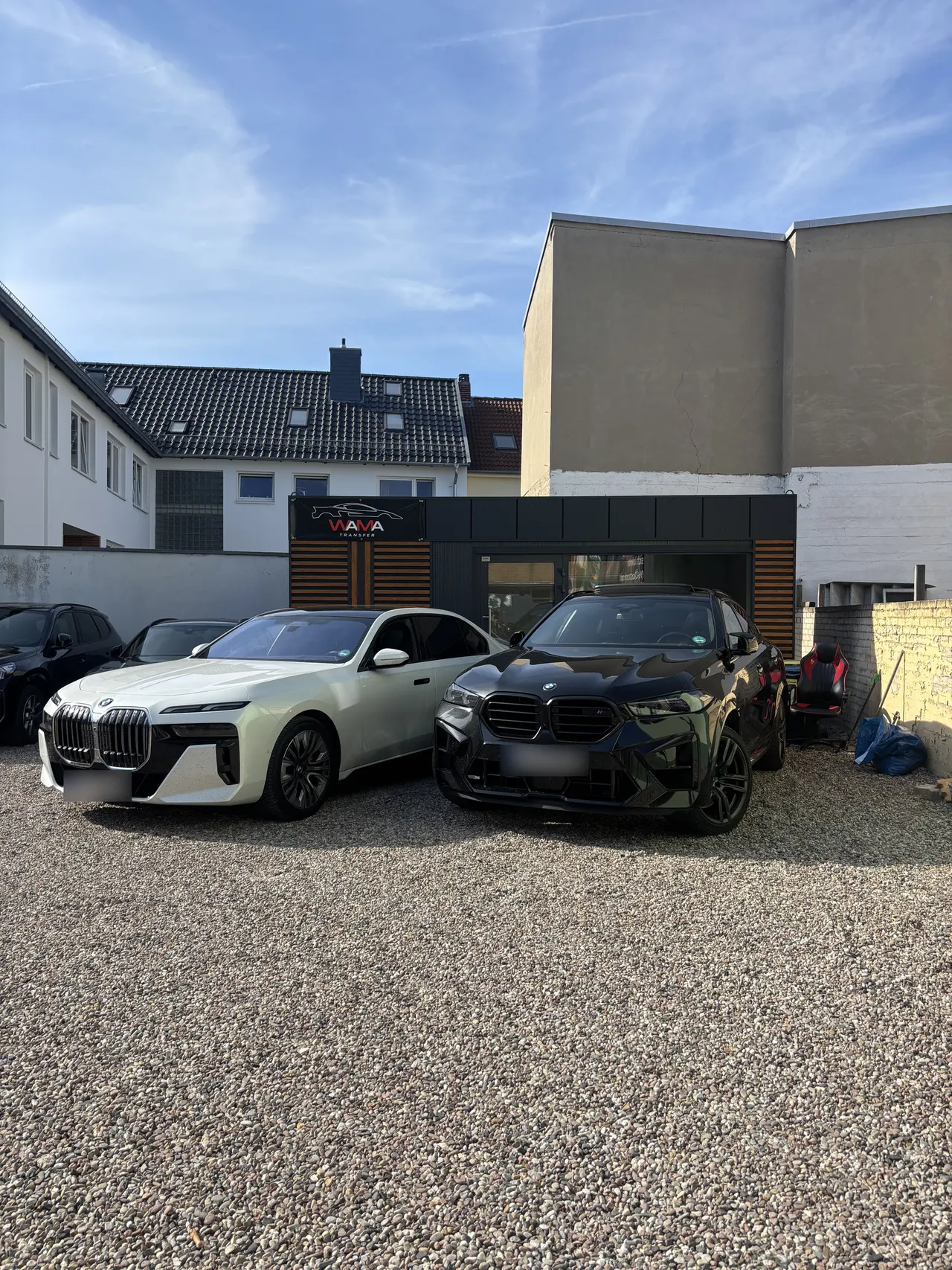 Fahrzeuge auf dem Kieshof vor dem Büro